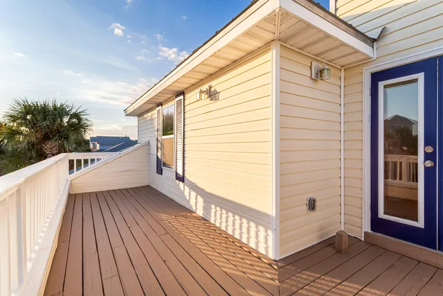 a view of a balcony with wooden floor and fence
