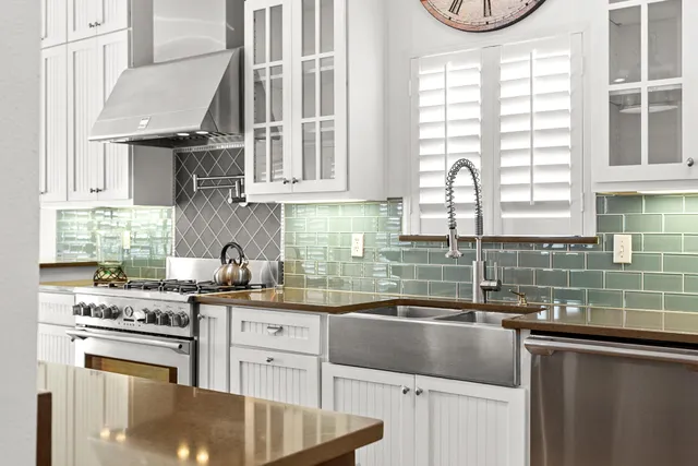 a kitchen with granite countertop a sink a stove and cabinets