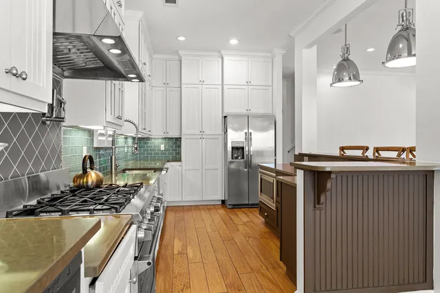 a kitchen with kitchen island a counter top space a sink stainless steel appliances and cabinets