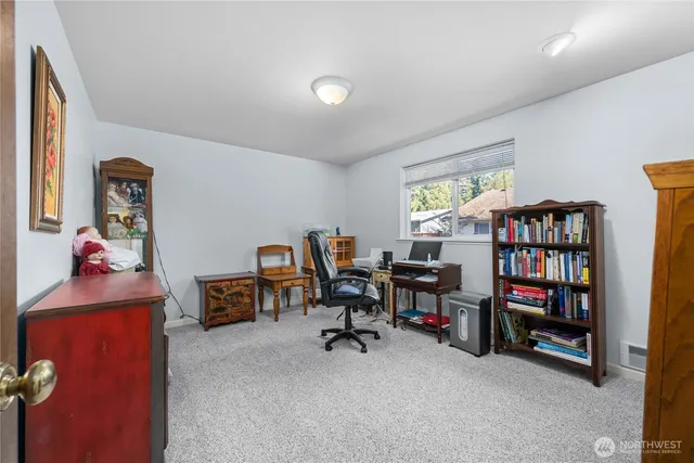 a view of a workspace with furniture and a bookshelf