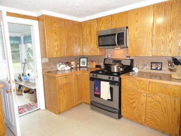 431 Spring Street Hanson, MA 02341 - Photo 5 of 21 a kitchen with stainless steel appliances granite countertop a stove a sink and a microwave