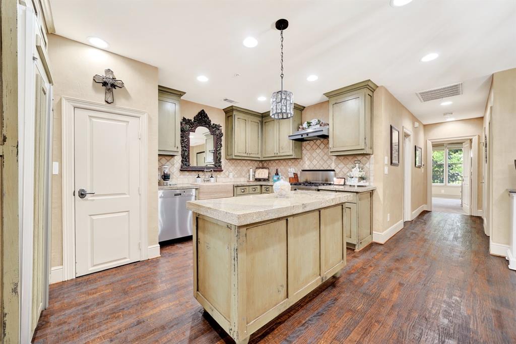 5055 Addison Circle, Unit 426 Addison, TX 75001 - Photo 13 of 38 a kitchen with stainless steel appliances kitchen island a hardwood floor and a sink