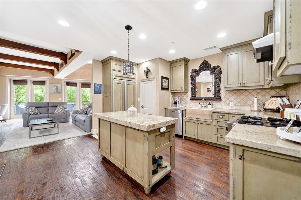 5055 Addison Circle, Unit 426 Addison, TX 75001 - Photo 20 of 38 a kitchen with a stove sink cabinets and wooden floor