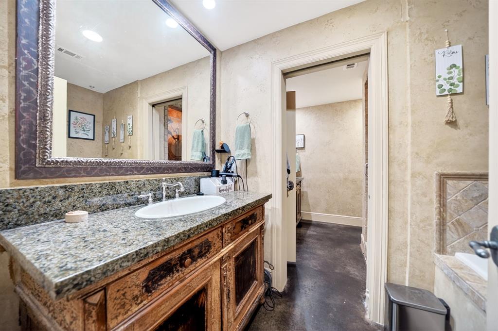 5055 Addison Circle, Unit 426 Addison, TX 75001 - Photo 21 of 38 a bathroom with a granite countertop sink and a mirror