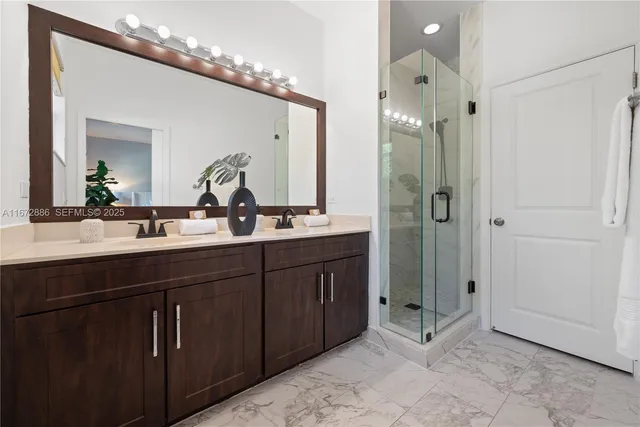 a bathroom with a double vanity sink mirror and shower