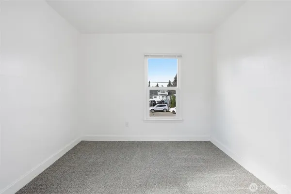 a view of a small space with wooden floor and a window