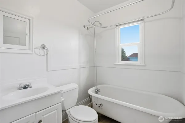 a white toilet sitting next to a bath tub