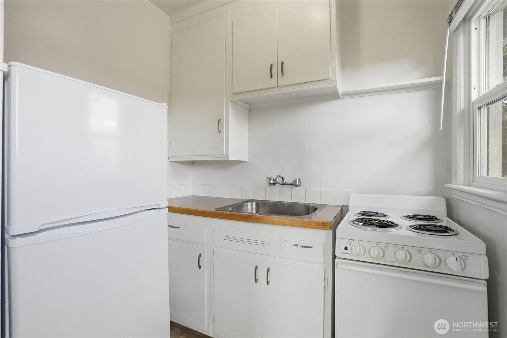 1704 North Ash Street Spokane, WA 99205 - Photo 8 of 23 a kitchen with cabinets and a stove top oven
