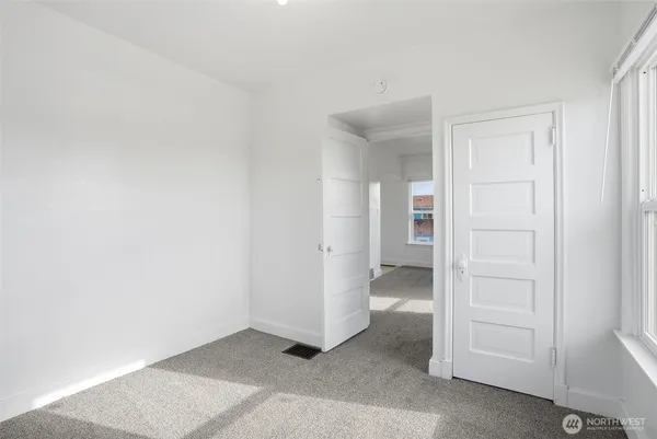 an empty room with a hallway and closet