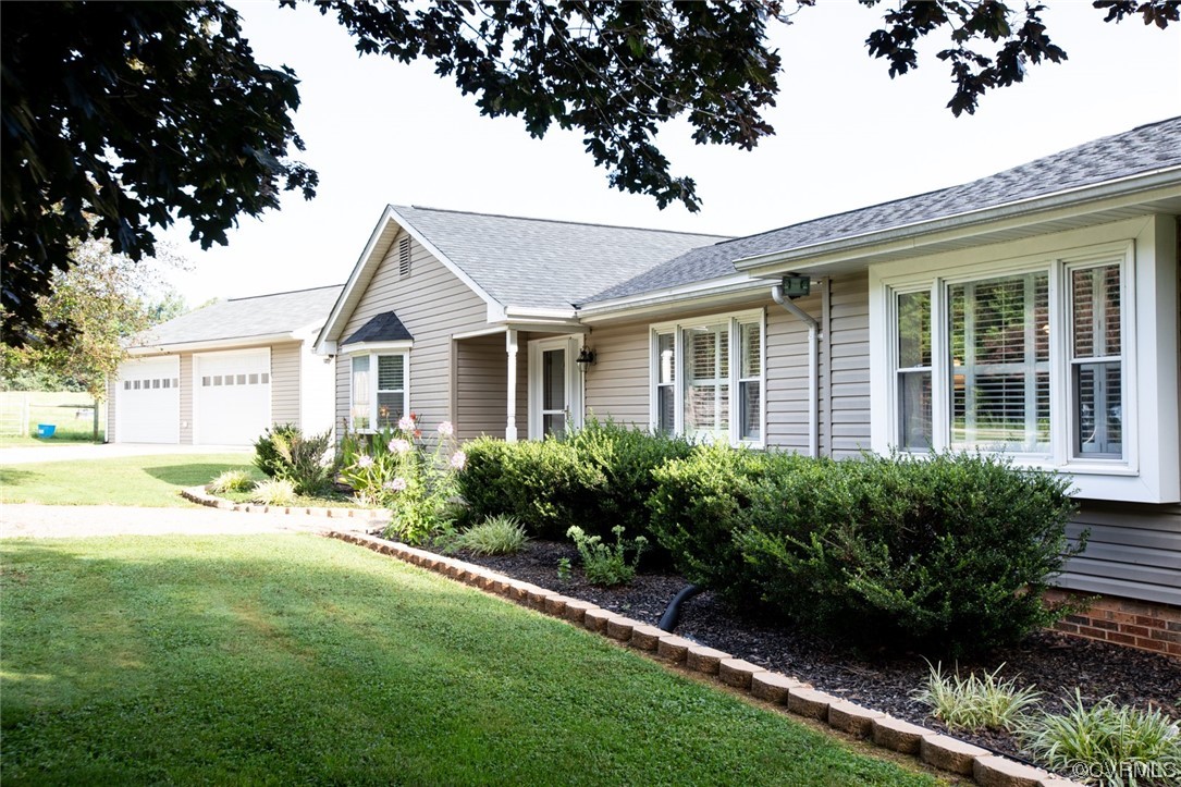 a front view of a house with a yard and potted plants