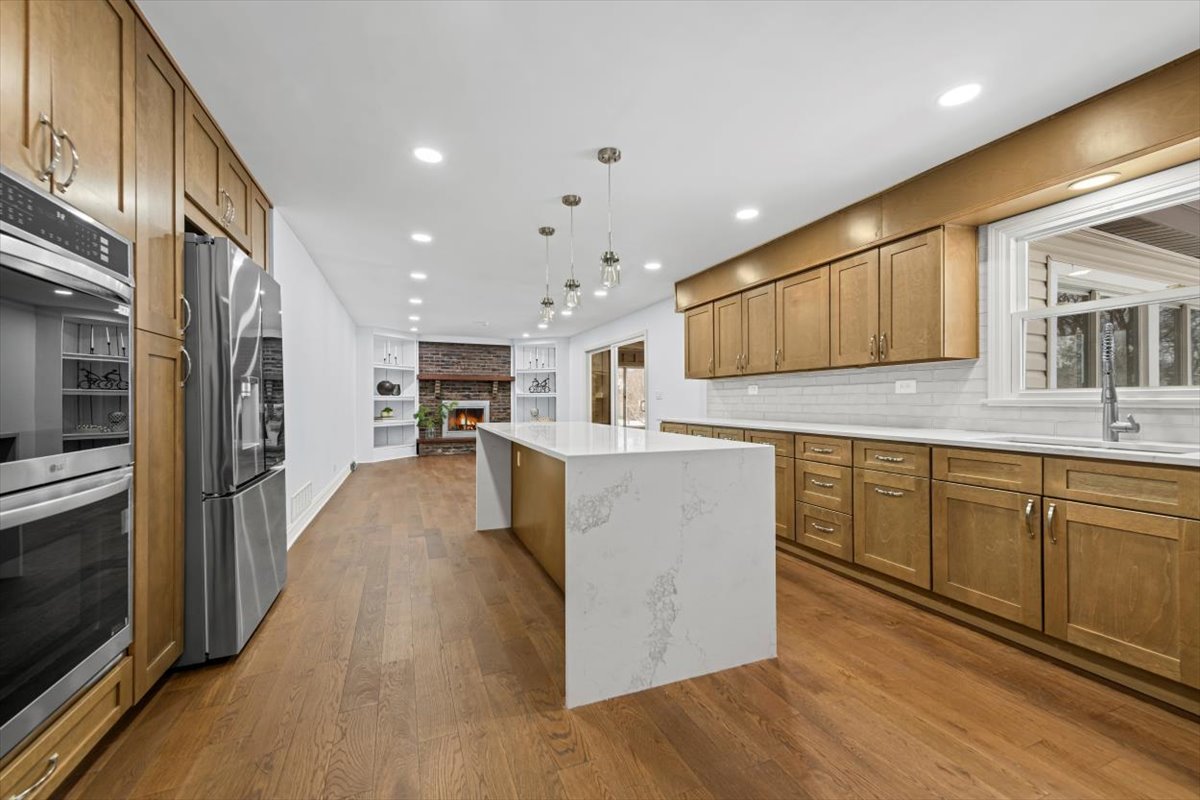 2527 Checker Road Long Grove, IL 60047 - Photo 4 of 32 a kitchen with stainless steel appliances granite countertop a stove top oven a sink dishwasher and a refrigerator with wooden floor