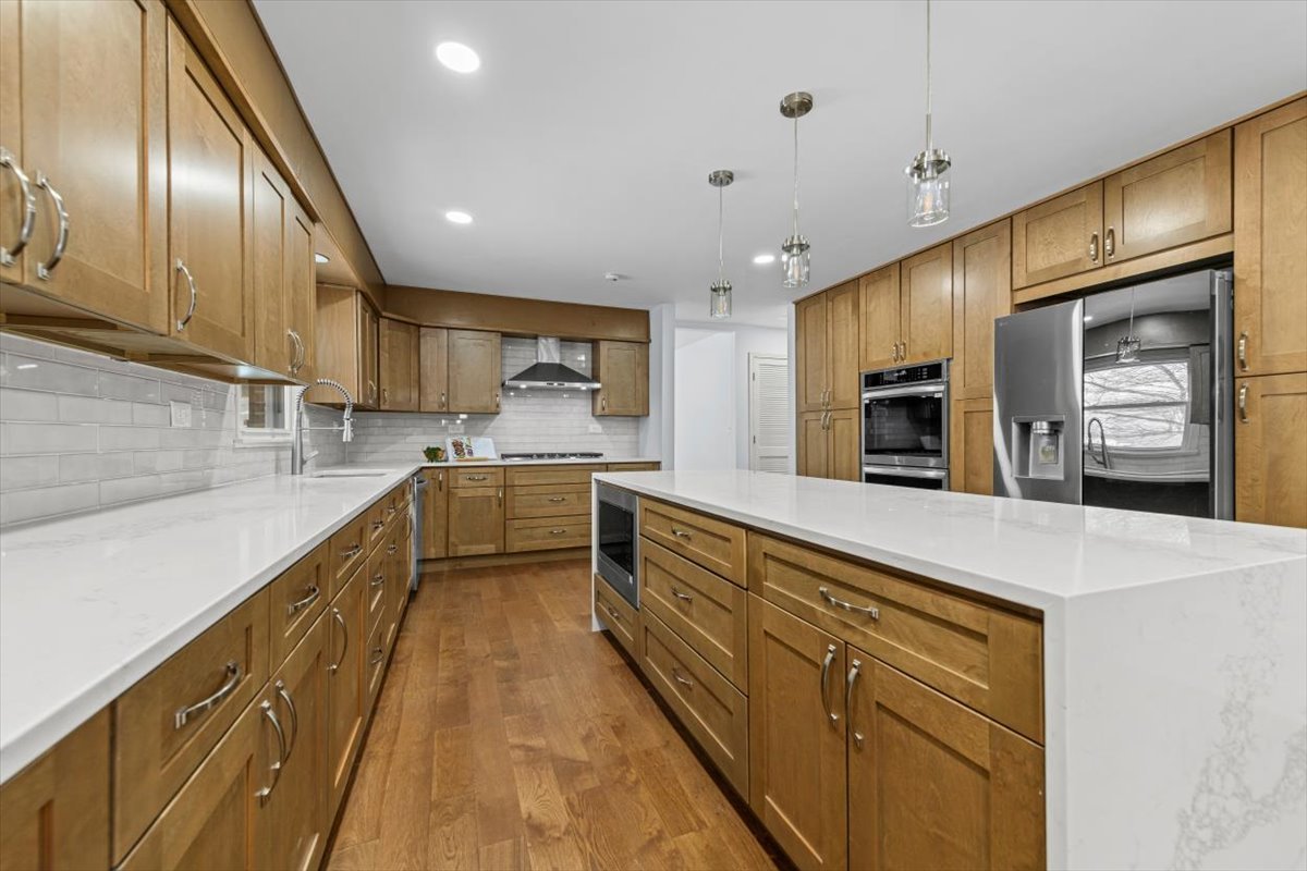 2527 Checker Road Long Grove, IL 60047 - Photo 5 of 32 a large kitchen with stainless steel appliances kitchen island a large counter top and a stove top oven