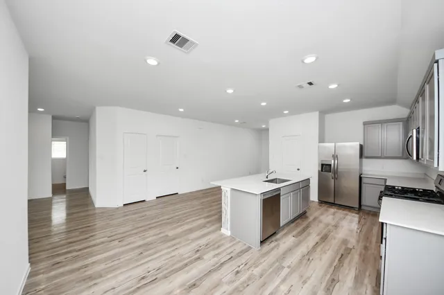 a kitchen with stainless steel appliances kitchen island a sink and a refrigerator