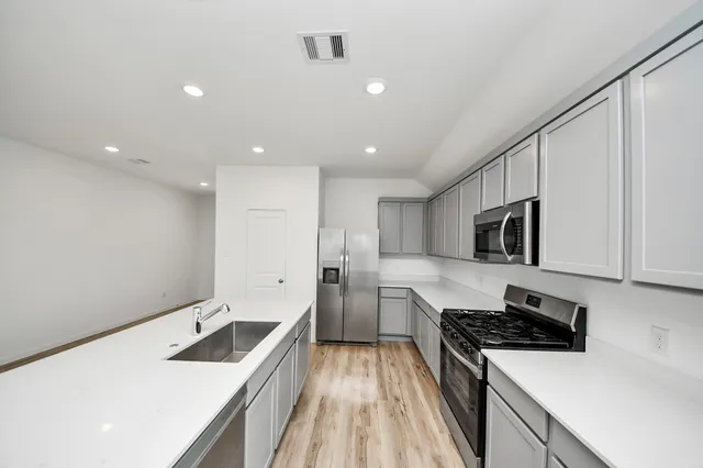 a kitchen with a sink stove and refrigerator
