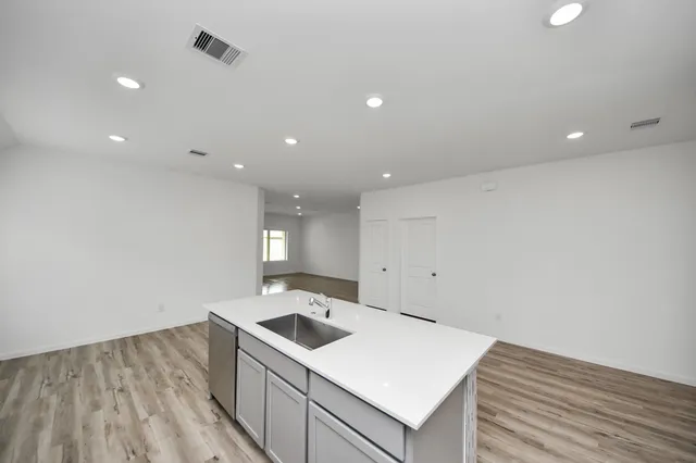 a kitchen with a sink cabinets and wooden floor