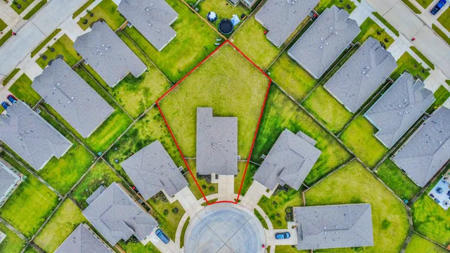 an aerial view of a house with a yard and outdoor seating