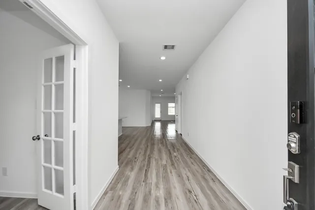 a view of a hallway with wooden floor
