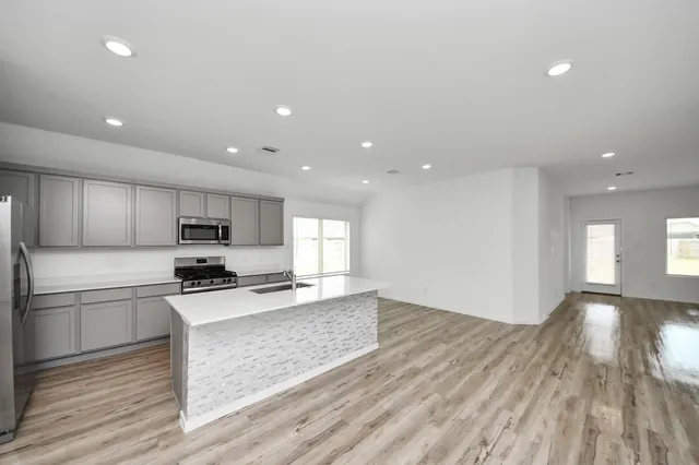 a kitchen with stainless steel appliances granite countertop a stove a sink and a refrigerator