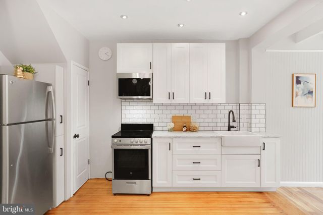 a kitchen with a sink a refrigerator and cabinets