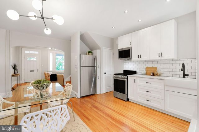 a kitchen with stainless steel appliances a sink dishwasher a refrigerator and a stove with wooden floor