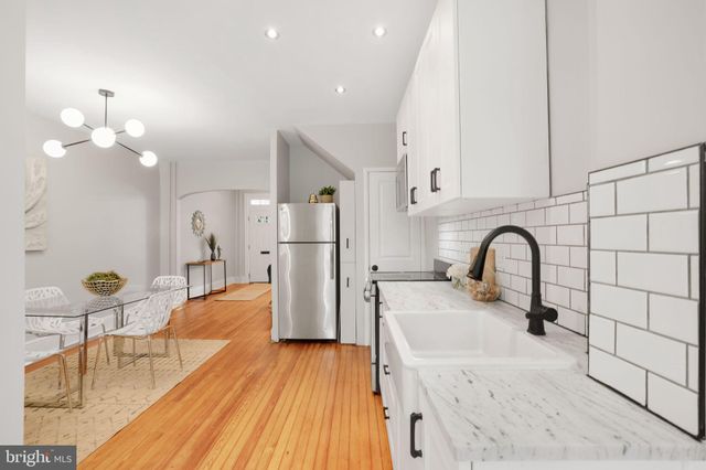 a view of a dining room with furniture a chandelier and wooden floor