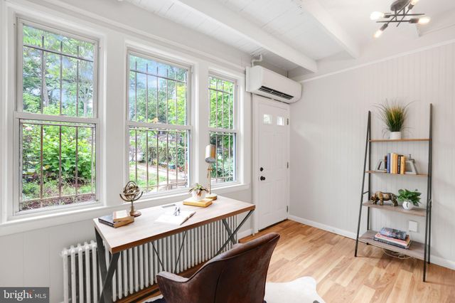 a dining room with large windows and wooden floor