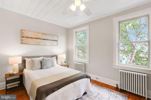 a bedroom with a bed and dresser with mirror