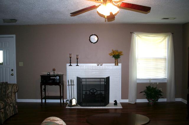 Step into the home through this lovely living room featuring hard wood floors and a gas log fireplace. 