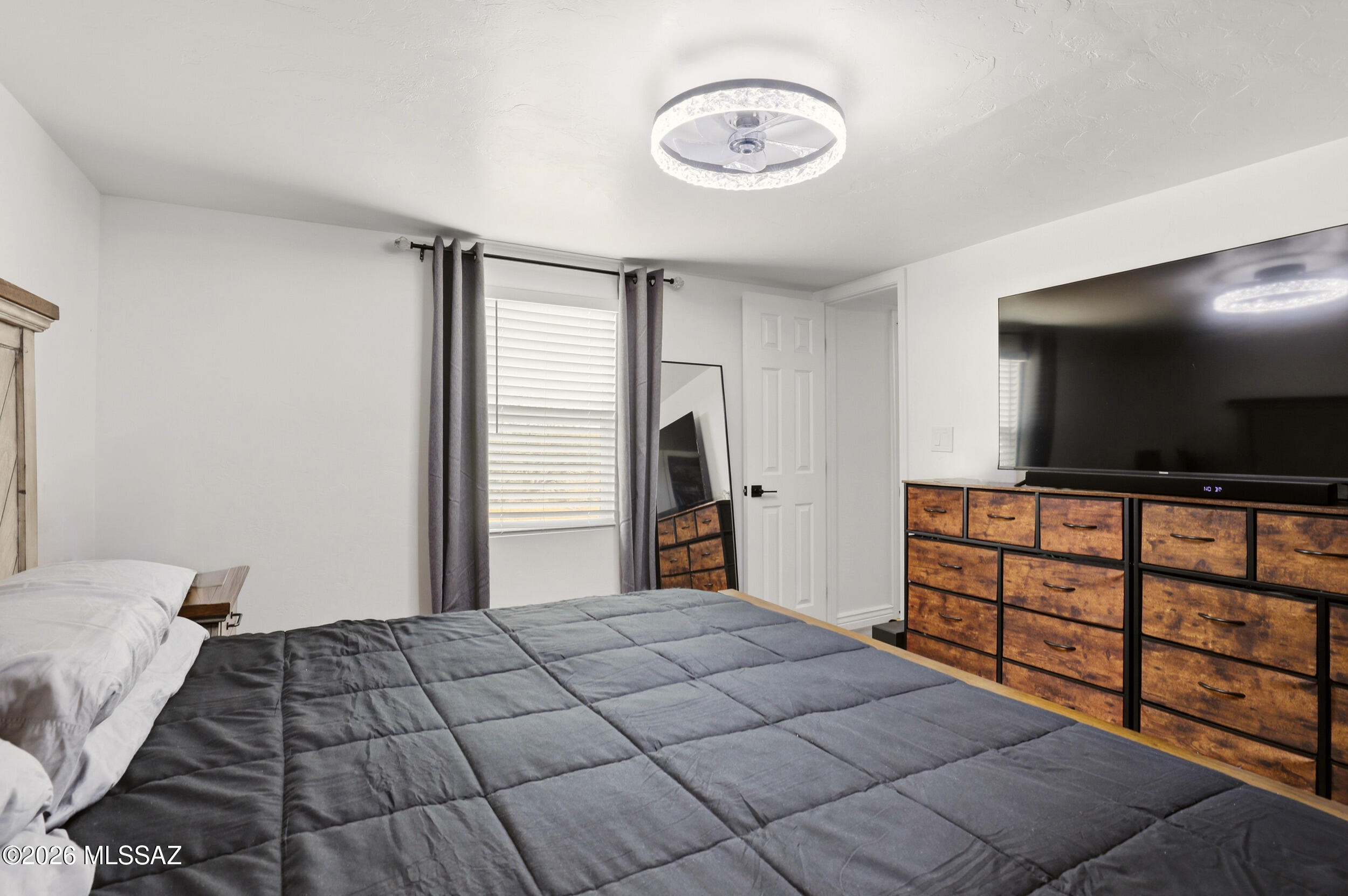 8620 South Sandario Road Tucson, AZ 85736 - Photo 15 of 26 a bedroom with a bed and a flat screen tv