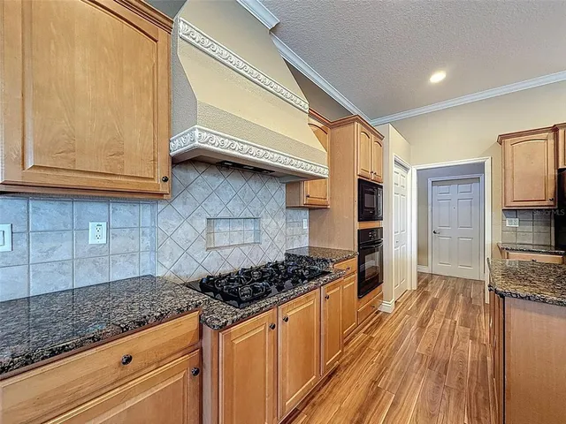 a kitchen with granite countertop a stove and cabinets