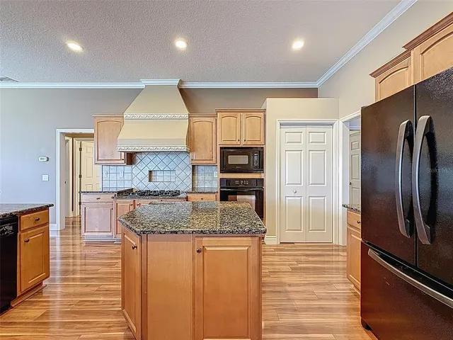a kitchen with stainless steel appliances granite countertop a refrigerator and a sink