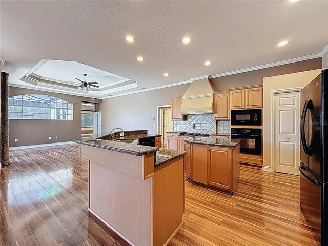 a kitchen with granite countertop a stove top oven and refrigerator