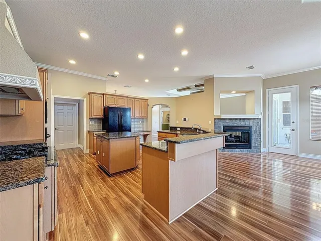a large kitchen with kitchen island a sink a counter top stainless steel appliances and cabinets