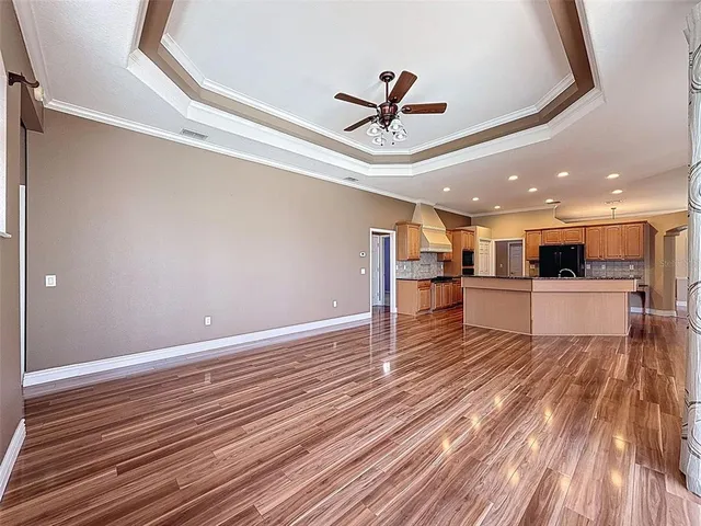 a view of a room with wooden floor and ceiling fan