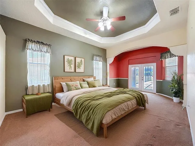 a spacious bedroom with a large bed and a chandelier