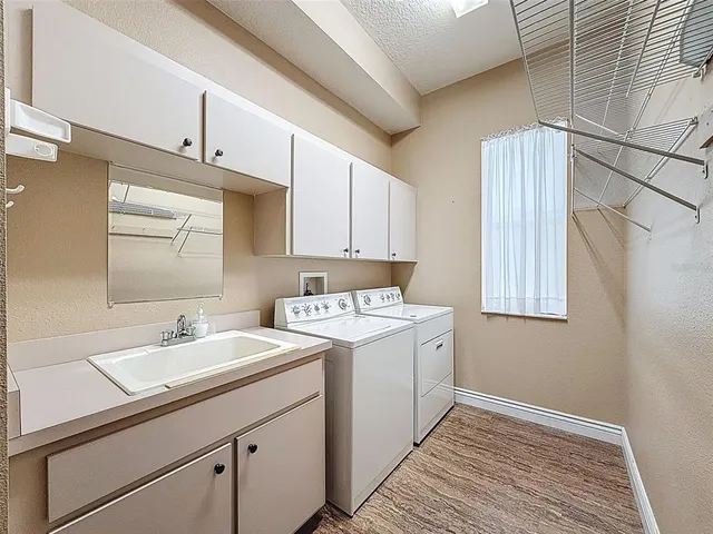 a utility room with cabinets washer and dryer