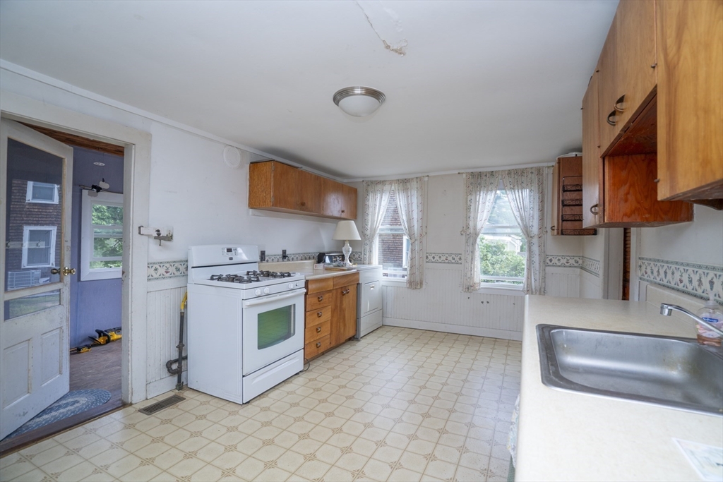 15 Beacon Street Amesbury, MA 01913 - Photo 6 of 41 a kitchen with a stove a sink and a refrigerator