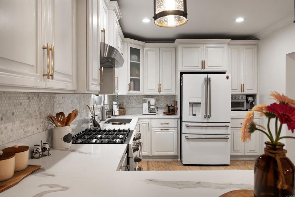 7965 4th Place Downey, CA 90241 - Photo 11 of 41 a kitchen with a refrigerator and white cabinets