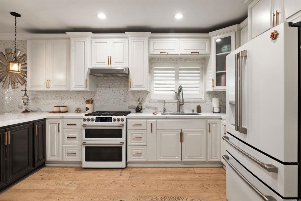 7965 4th Place Downey, CA 90241 - Photo 10 of 41 a kitchen with stainless steel appliances white cabinets and white appliances