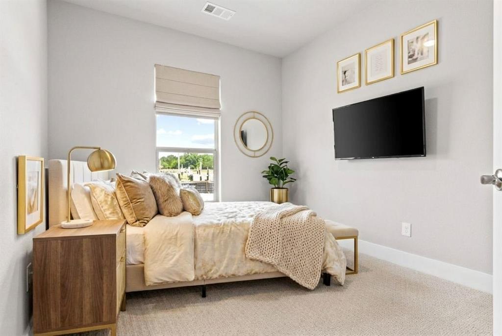12831 Pne Rdg Trail Wylie, TX 75098 - Photo 6 of 12 a bedroom with a bed a flat tv screen and a dresser