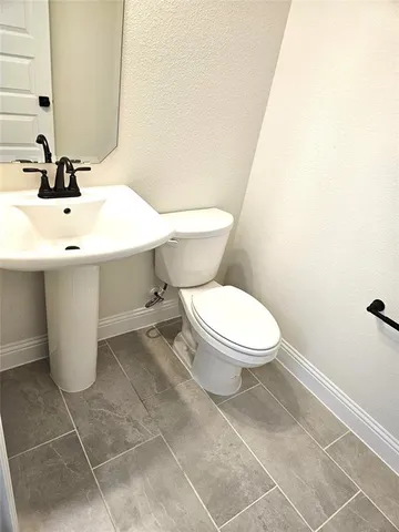 a bathroom with a sink a toilet and mirror