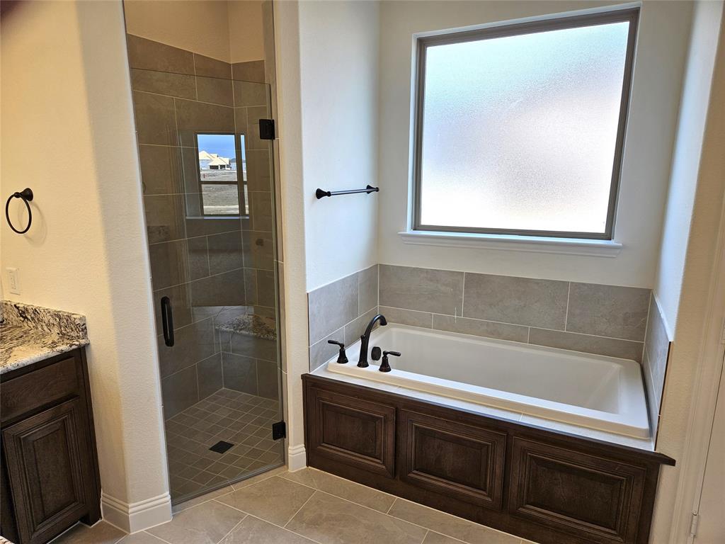 1453 Enloe Road Howe, TX 75459 - Photo 20 of 33 a bathroom with a bathtub and a shower