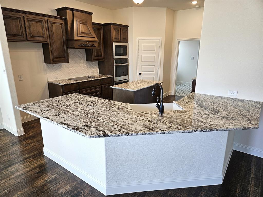 1453 Enloe Road Howe, TX 75459 - Photo 2 of 33 a kitchen with kitchen island granite countertop a sink and a wooden cabinets