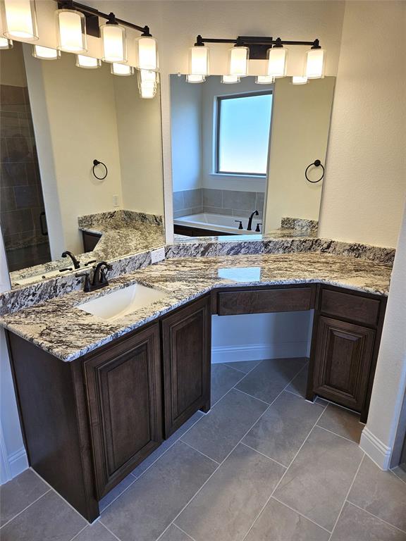 1453 Enloe Road Howe, TX 75459 - Photo 24 of 33 a bathroom with a granite countertop sink a mirror and a wooden cabinets