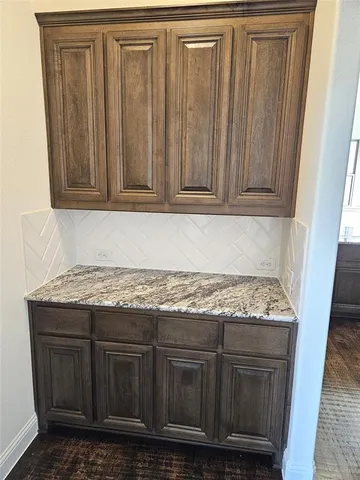 a utility room with granite countertop wooden cabinets
