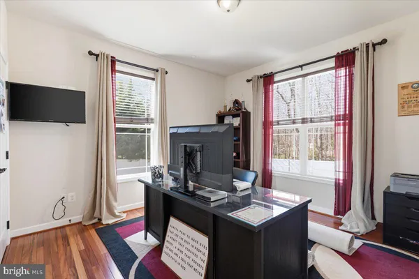 a large kitchen with stainless steel appliances kitchen island granite countertop a refrigerator a stove a sink and white cabinets with wooden floor