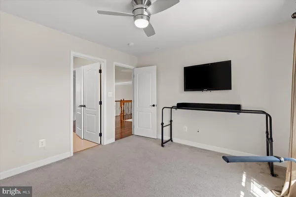 a view of a room with gym equipment and wooden floor