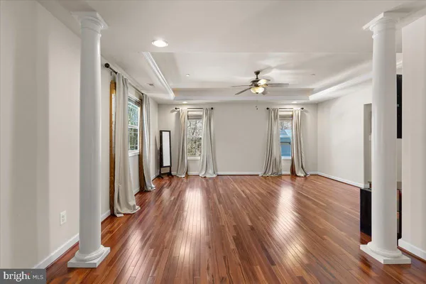 a view of a room with wooden floor and ceiling fan