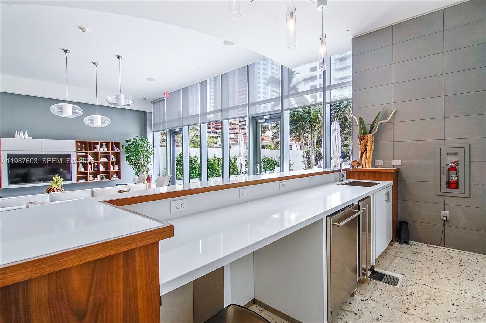 460 Northeast 28th Street, Unit 1601 Miami, FL 33137 - Photo 37 of 41 a kitchen with a sink a counter top space stainless steel appliances and a large window