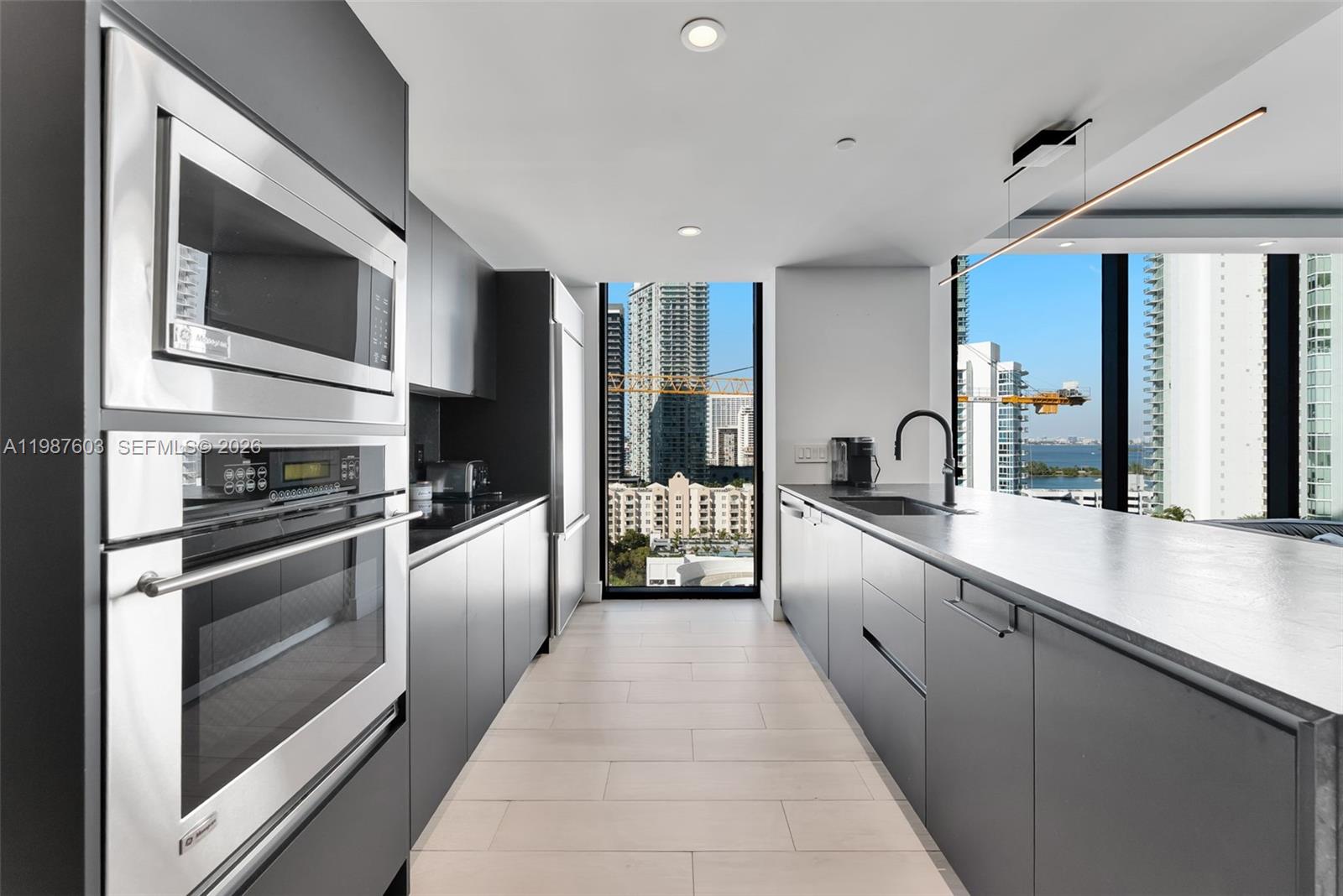 460 Northeast 28th Street, Unit 1601 Miami, FL 33137 - Photo 7 of 41 a large white kitchen with stainless steel appliances granite countertop a large stove top oven and refrigerator